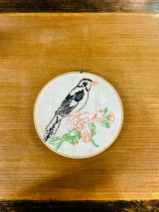 Embroidery Hoop With Hand-Stitched Bird Perched on Floral Banner